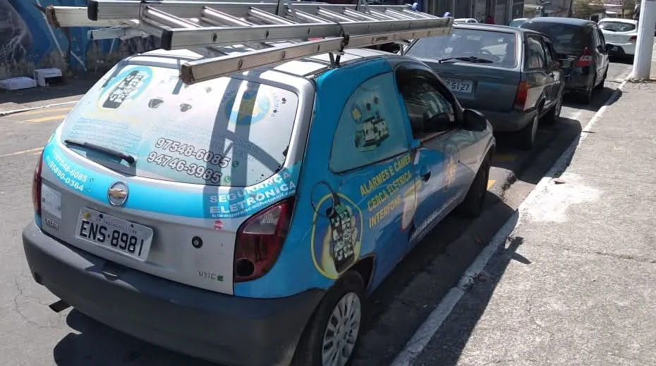 Veículo azul identificado da KL Segurança Eletrônica em via urbana